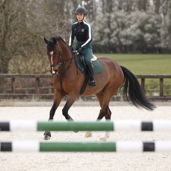 Rider wearing Aubrion Team Winter Baselayer in Green