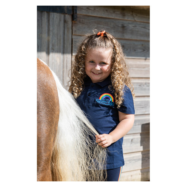 Child grooming pony wearing Rainbow Riders Polo Shirt